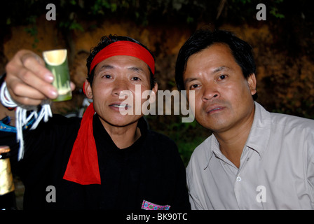 Cheers, les hommes de l'ethnie Phunoi clinking glasses avec LAO Lao laotien, le vin de riz en bambou, navires, Laos, Sud Phongsali Banque D'Images