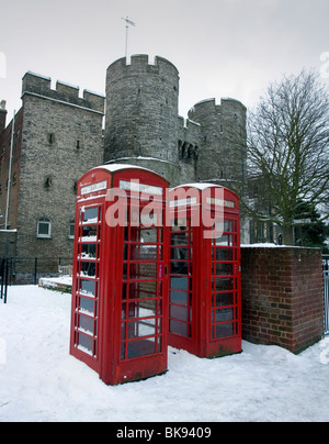 Des cabines téléphoniques et Westgate Towers couvertes de neige à Canterbury, Kent, UK. Banque D'Images