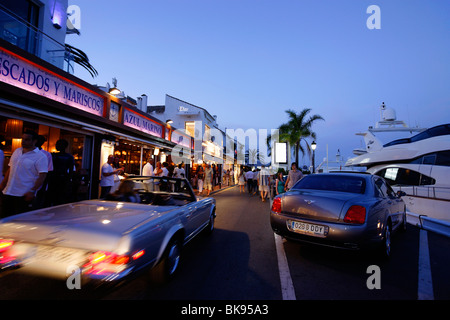 Les voitures de luxe, les restaurants à proximité de port, Puerto Banus, Marbella, Andalousie, Espagne Banque D'Images