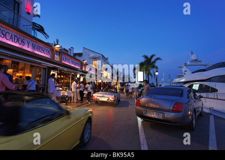 Les voitures de luxe, les restaurants à proximité de port, Puerto Banus, Marbella, Andalousie, Espagne Banque D'Images