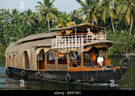 Femme se prélasser sur une terrasse d'kettuvallam, un style traditionnel péniche du Kerala backwaters. Banque D'Images