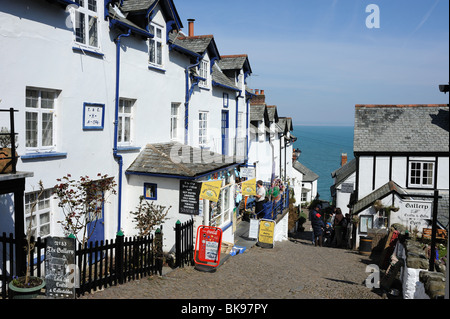 Rue en pente dans le village de Clovelly North Devon avec mer bleue et le ciel en arrière-plan Banque D'Images