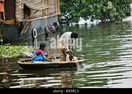 Contrôle de pêcheur ses filets dans un canal de remous dans le Kerala, en Inde. Banque D'Images