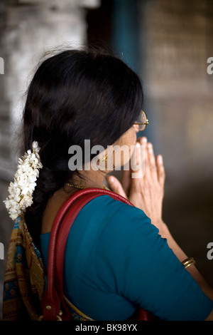 Une femme avec des fleurs de jasmin dans les cheveux, prie à un culte dans le Temple de Murugan Swamimalai, Tamil Nadu, Inde Banque D'Images