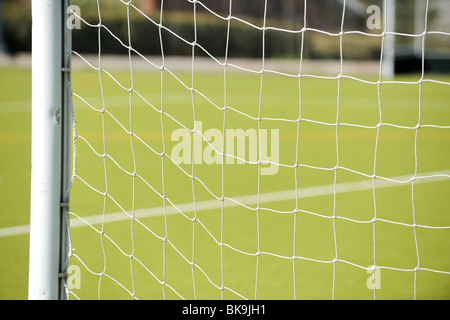 Un gros plan d'un but de Soccer net avec l'herbe verte derrière. Banque D'Images