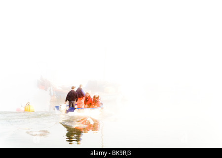 Un petit bateau avec des pêcheurs, des chefs À LEUR PLUS GRAND BATEAU DANS LA BRUME MATINALE Banque D'Images