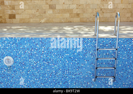 Sol carrelé bleu piscine vide sur une journée ensoleillée sans eau Banque D'Images