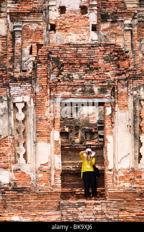 Wat Chaiwatthanaram temple bouddhiste d'Ayutthaya, Thaïlande, avec femme visiteur photographier les ruines. Banque D'Images