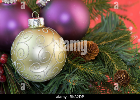 Boule de Noël or et argent sur la conception de défilement avec cône de branches de sapin Banque D'Images