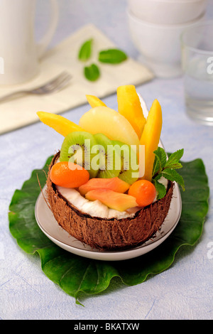 Salade de fruits tropicaux dans une noix de coco. Recette disponible. Banque D'Images