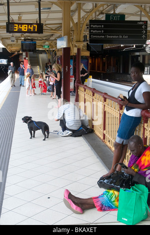 Groupe multiculturel de passagers en attente sur une plate-forme à la gare de Flinders Street, Melbourne, Australie Banque D'Images