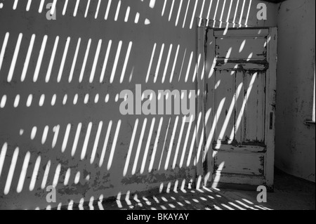 La lumière pénètre à travers le vieux plancher casting shadows sur les murs, Buchhalter Maison à Kolmanskop près de Lüderitz, Namibie Banque D'Images