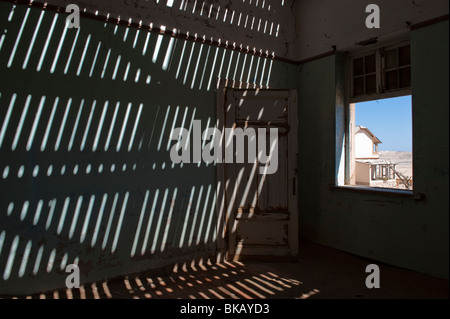 La lumière pénètre à travers le vieux plancher casting shadows sur les murs, Buchhalter Maison à Kolmanskop près de Lüderitz, Namibie Banque D'Images