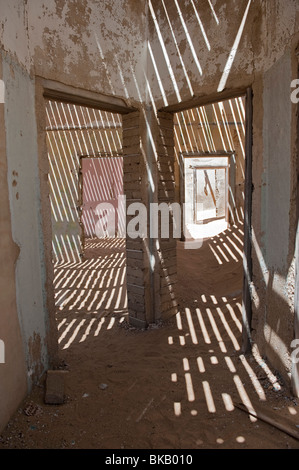 La lumière pénètre à travers le vieux plancher casting shadows dans les ingénieurs maison à Kolmanskop près de Lüderitz, Namibie Banque D'Images