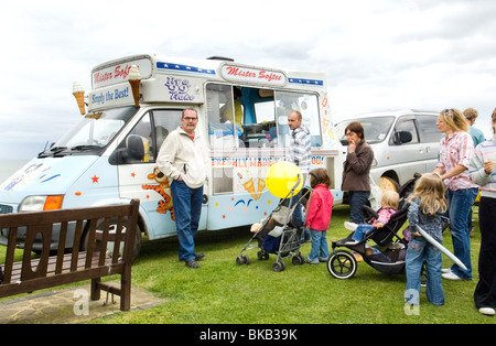 Mr Softee ice cream van et de la file d'attente, Woman at seaside vendeur de glaces. Une glace van avec les enfants. Un mobile ice cream van. Banque D'Images