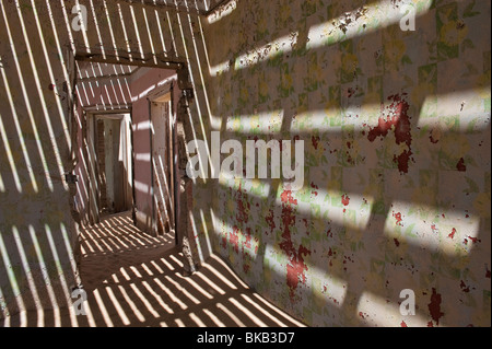 Pentrates la lumière à travers le vieux plancher casting shadows sur les murs, les ingénieurs maison à Kolmanskop près de Lüderitz, Namibie Banque D'Images