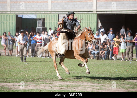 Les jeunes gaucho argentin équitation son cheval dans une compétition à San Marcos Sierras, Cordoba, Argentine Banque D'Images