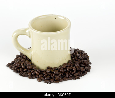 Tasse à café emblématique dans les fèves de café sur fond blanc Banque D'Images