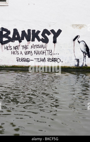 Banksy graffiti sur un mur de briques blanchis sur le côté de Regents Canal près de Camden Lock North London UK Banque D'Images