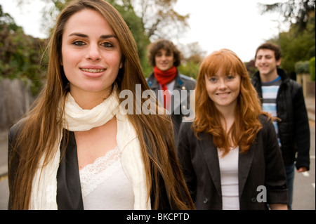 Groupe d'adolescents marchant dans la rue avec une fille avec de longs cheveux bruns et les accolades sur ses dents ouvre la voie Banque D'Images