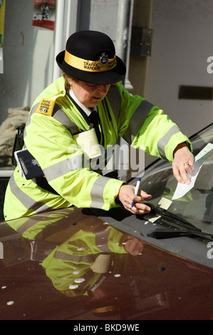 Le trafic d'une femme préfet l'émission d'un ticket de parking pour une voiture qui a déjà deux billets émis déjà, Aberystwyth Wales UK Banque D'Images