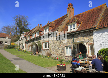 Les clients à la Tiger Inn prendre un verre sur la place du village à l'East Dean, East Sussex. Banque D'Images