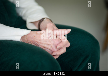 Closeup of old woman's hands dans lap. Banque D'Images