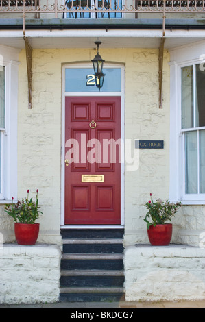 Porte avant rouge numéro 21 avec imposte de maison d'époque avec des étapes et des plantes en pots Penarth Vale of Glamorgan South Wales UK Banque D'Images