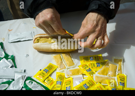 Un festival faim présence met la moutarde sur un hot dog à New York le dimanche, 18 avril, 2010. (© Richard B. Levine) Banque D'Images