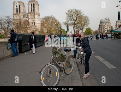 Les gens Cyclisme dans la rue, Paris, France, les adolescentes touristiques filles prendre des photos près de la cathédrale notre Dame, les femmes vélo hors europe Banque D'Images