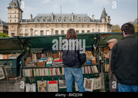 Les touristes naviguant, vieux livres en vente marché extérieur, Paris, France, quai de Seine, Bouquinistes, Vendeurs de livres anciens, livres d'occasion france Banque D'Images