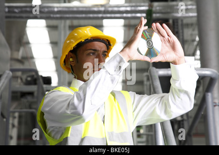 Directeur d'usine se penche sur CD, vu de loin. Banque D'Images
