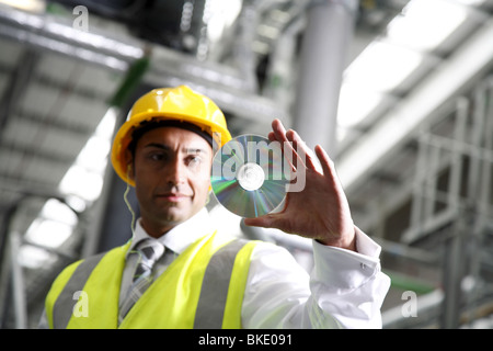 Directeur d'usine se penche sur CD, vu de loin. Banque D'Images