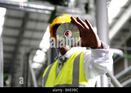 Directeur d'usine se penche sur CD, vu de loin. Banque D'Images