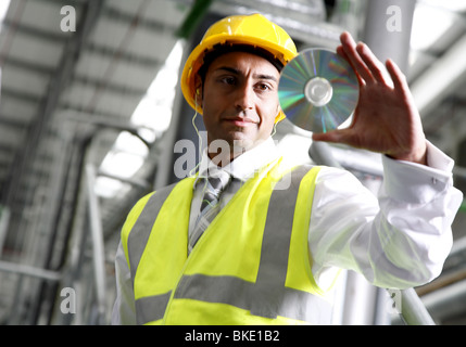 Directeur d'usine se penche sur CD, vu de loin. Banque D'Images