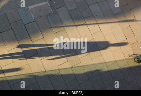 Les piétons casting de longues ombres sur le trottoir à Leicester UK Banque D'Images