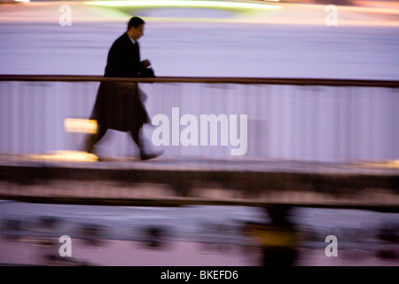 Personne qui marche sur une passerelle le long du lac Tjornin (blurred motion). Le centre de Reykjavik en Islande Banque D'Images