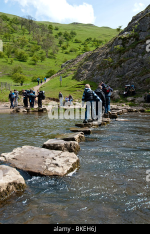 Les jeunes traversant les tremplins à Dovedale dans le parc national de Peak District, Derbyshire, Angleterre. Banque D'Images