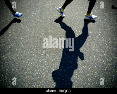 Ombres de flexion jambes, tout en participant à la course de marathon. Banque D'Images