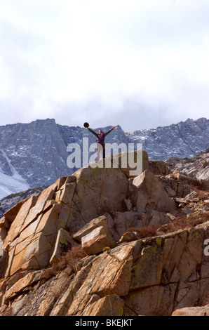 Célébrer l'homme après avoir atteint un jalon sur son ascension de la montagne Banque D'Images