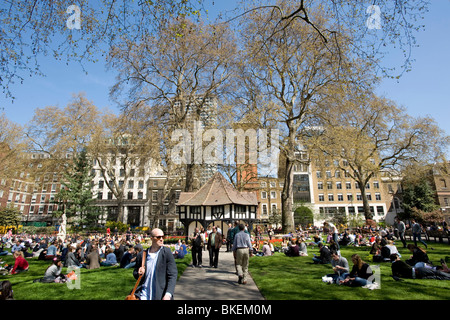 Les gens se reposer sur le printemps chaud dans Soho Square, W1, Londres, Royaume-Uni Banque D'Images