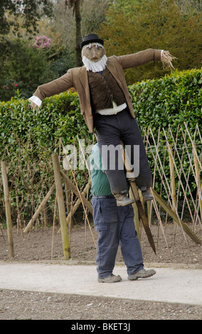 Déménagement jardinier un épouvantail devant le binage et la plantation des légumes à Heligan Gardens Cornwall dans l'Ouest Pays Angleterre UK Banque D'Images