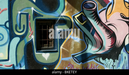 Chambre décorée avec des graffitis colorés et fenêtre sur mur de béton Banque D'Images