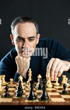 Déplacement d'une pièce d'échecs de l'homme sur l'échiquier en bois Banque D'Images