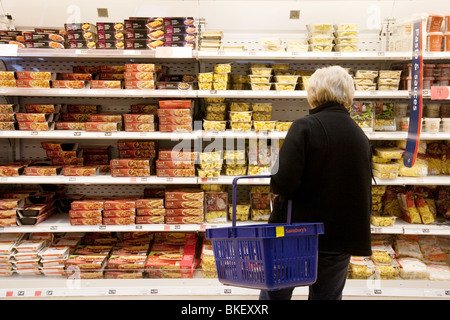 Une vieille femme shopping dans un supermarché Sainsburys London, UK Banque D'Images