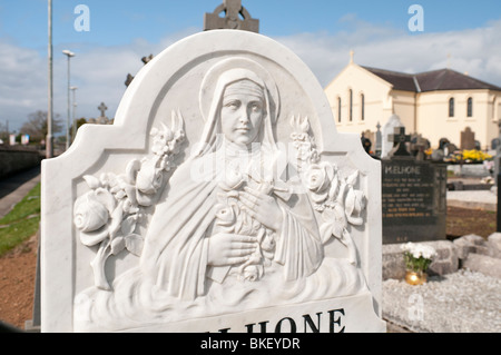 Pierre tombale richement sculpté montrant la Vierge Marie portant un crucifix. Banque D'Images