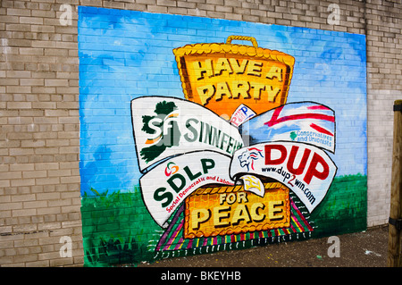 Peinture murale sur un mur avec des bannières d'élection pour le Sinn Fein, Parti unioniste de l'Ulster, SDLP et le Parti unioniste démocratique. Banque D'Images