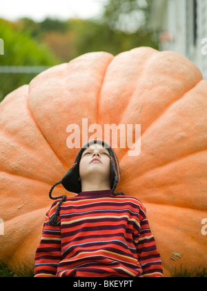 Garçon reposant sur grand pumpkin Banque D'Images