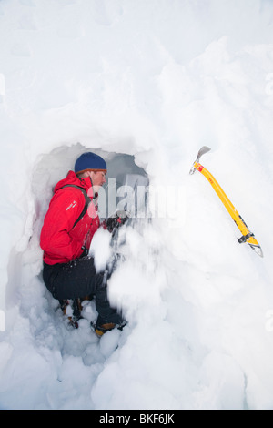 Un groupe d'alpinistes sur les trous de neige bâtiment dans le Cairngorm National de Cairngorms, en Écosse au Royaume-Uni. Banque D'Images