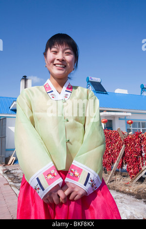 Zhang Xinru un Sud-Coréens ethniques emigre près de Linfen ville dans le nord de la Chine en face de sa maison avec des panneaux solaires sur le toit Banque D'Images